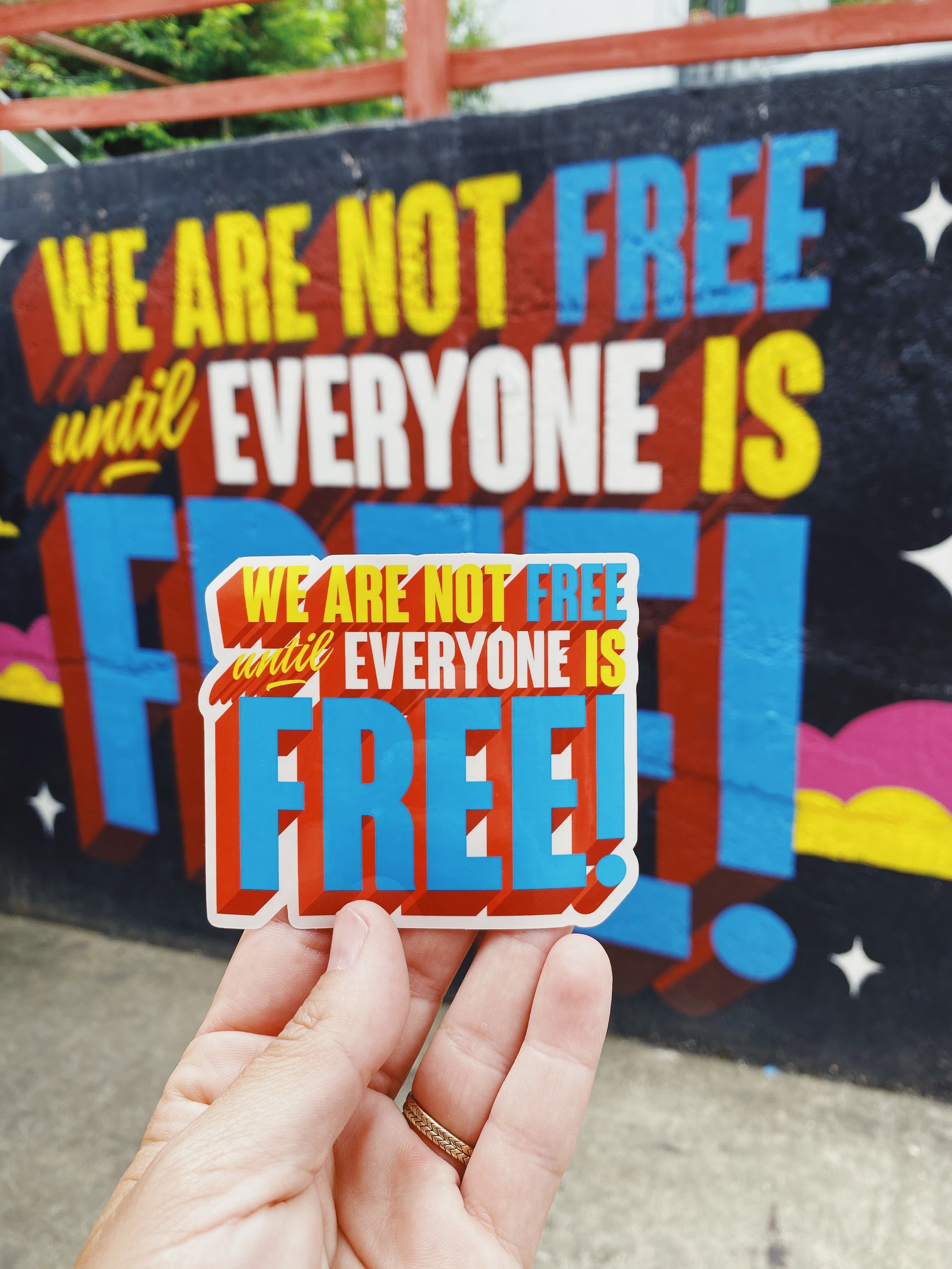 Sticker with the phrase 'We Are Not Free Until Everyone Is Free' in bold letters, symbolizing solidarity and the fight for freedom and equality for all.