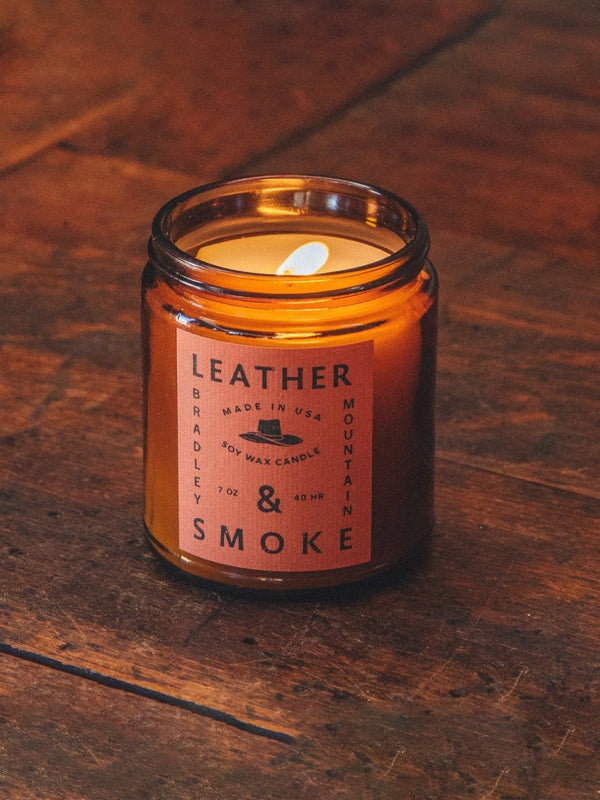 A 7 oz. Leather & Smoke candle, offering a rich, smoky fragrance with earthy leather notes, perfect for creating a cozy, warm ambiance in any room.