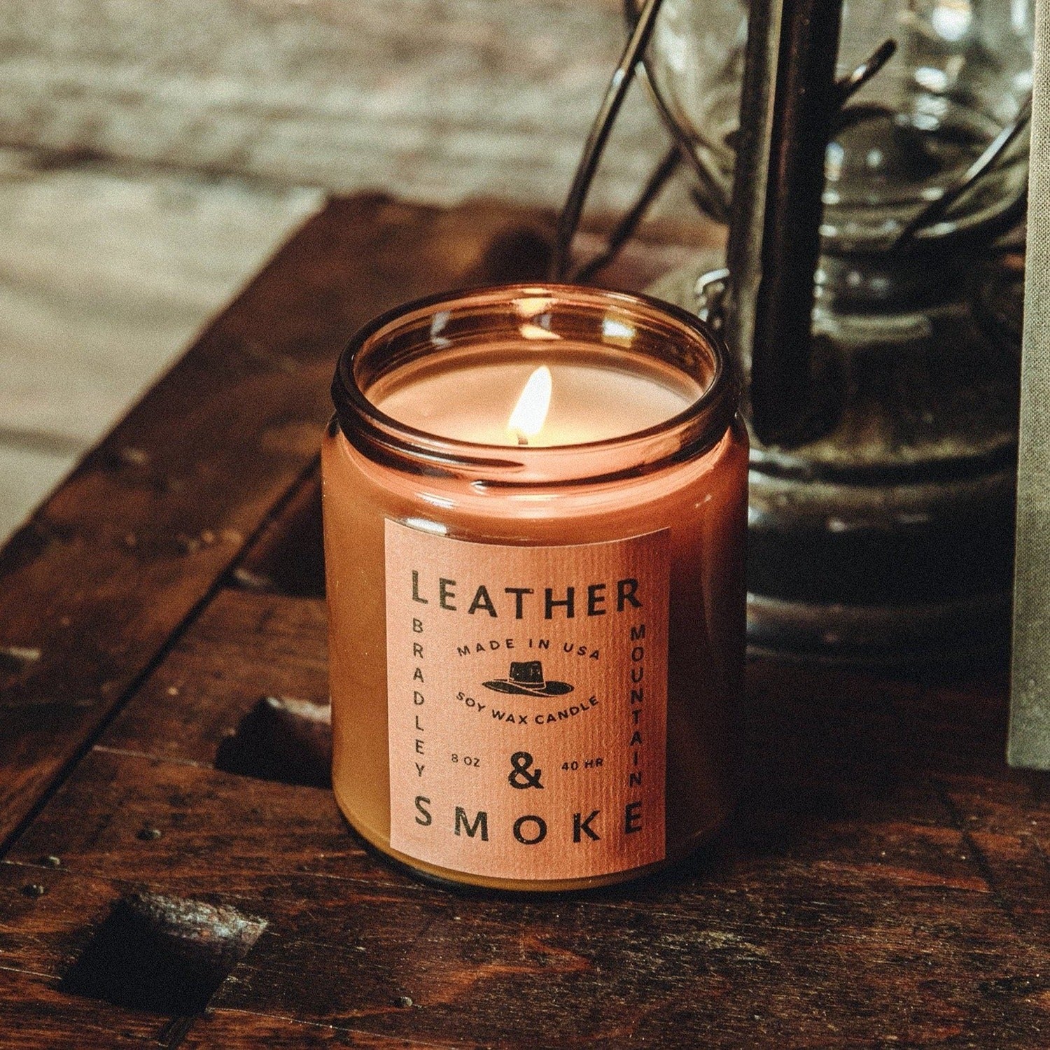 A 7 oz. Leather & Smoke candle, offering a rich, smoky fragrance with earthy leather notes, perfect for creating a cozy, warm ambiance in any room.