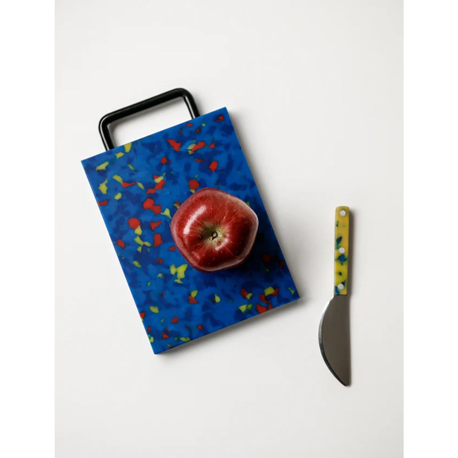 A small blue cutting board with a handle, designed for easy handling and compact storage.