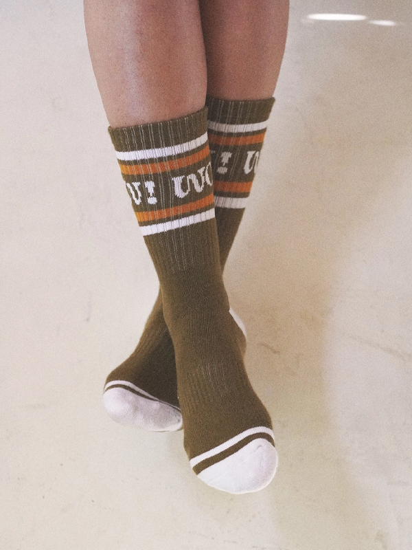 Pair of olive-green socks with the word 'Wow!' embroidered in bold, stylish lettering.