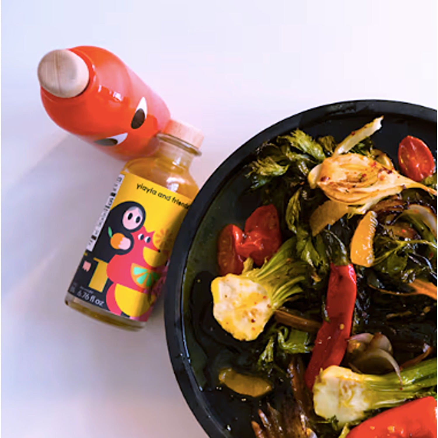 A bottle of Yiayia & Friends Extra Virgin Olive Oil infused with chili pepper, offering a spicy and flavorful kick for cooking and drizzling over dishes.