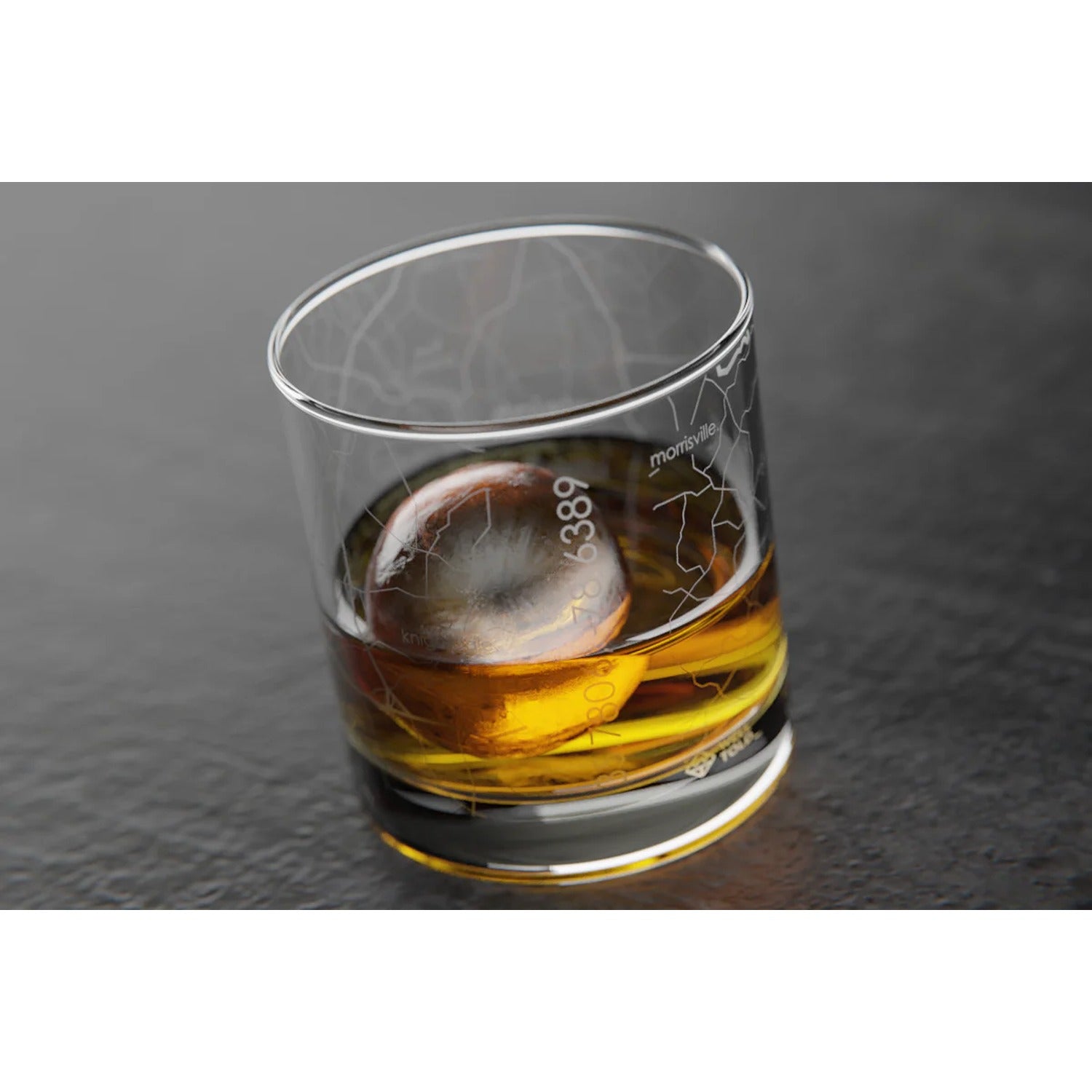 Rocks whiskey glass featuring an etched map of Raleigh, North Carolina, with streets and landmarks, perfect for sipping whiskey while celebrating the city.