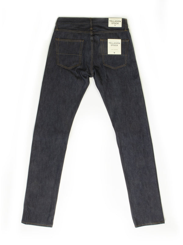A pair of slim tapered jeans in a classic denim wash, featuring a sleek, fitted silhouette that narrows at the ankle, designed for a modern, stylish fit.